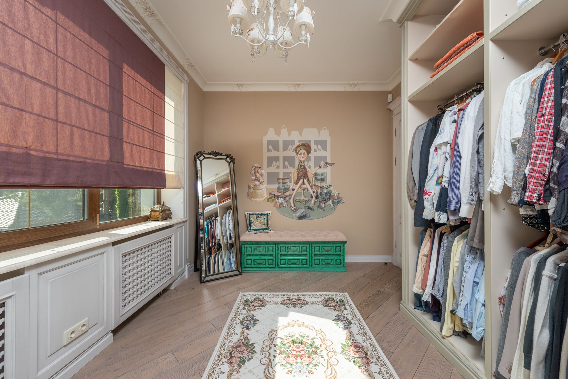 Elegant walk-in closet with clothes, chandelier, and a full-length mirror.