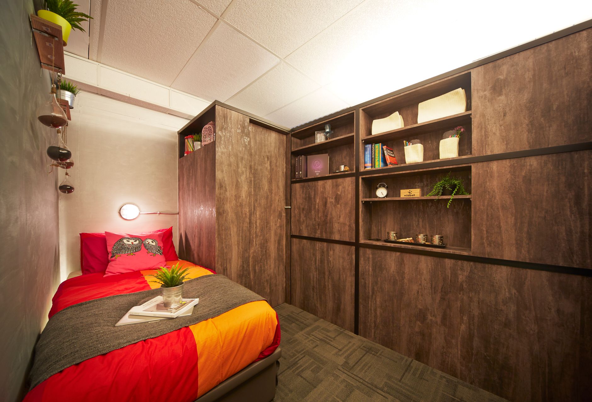 Simple bedroom interior design with colorful bed and wooden cabinet along wall in house