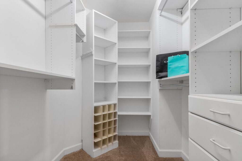 Explore a spacious white closet interior featuring shelves, drawers, and a clean design ideal for modern living.