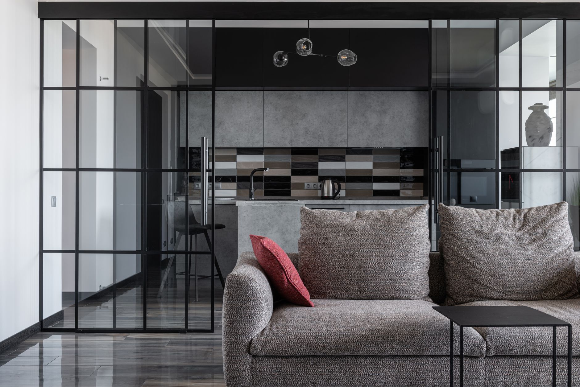 Contemporary living room with cozy sofa and open kitchen view.